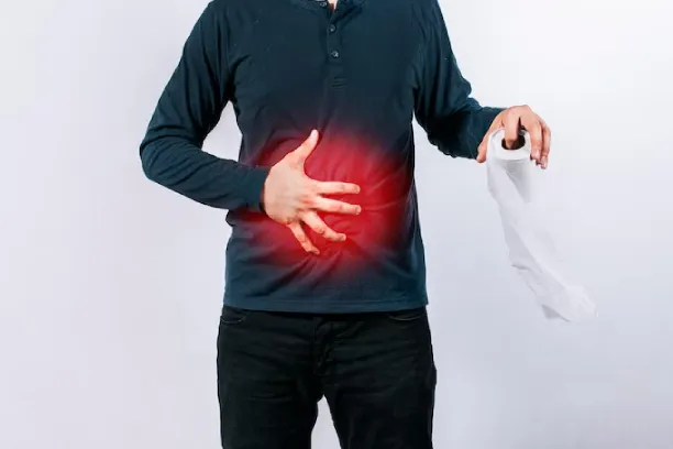 Man holding stomach with pain highlight and tissue, indicating diarrhoea
