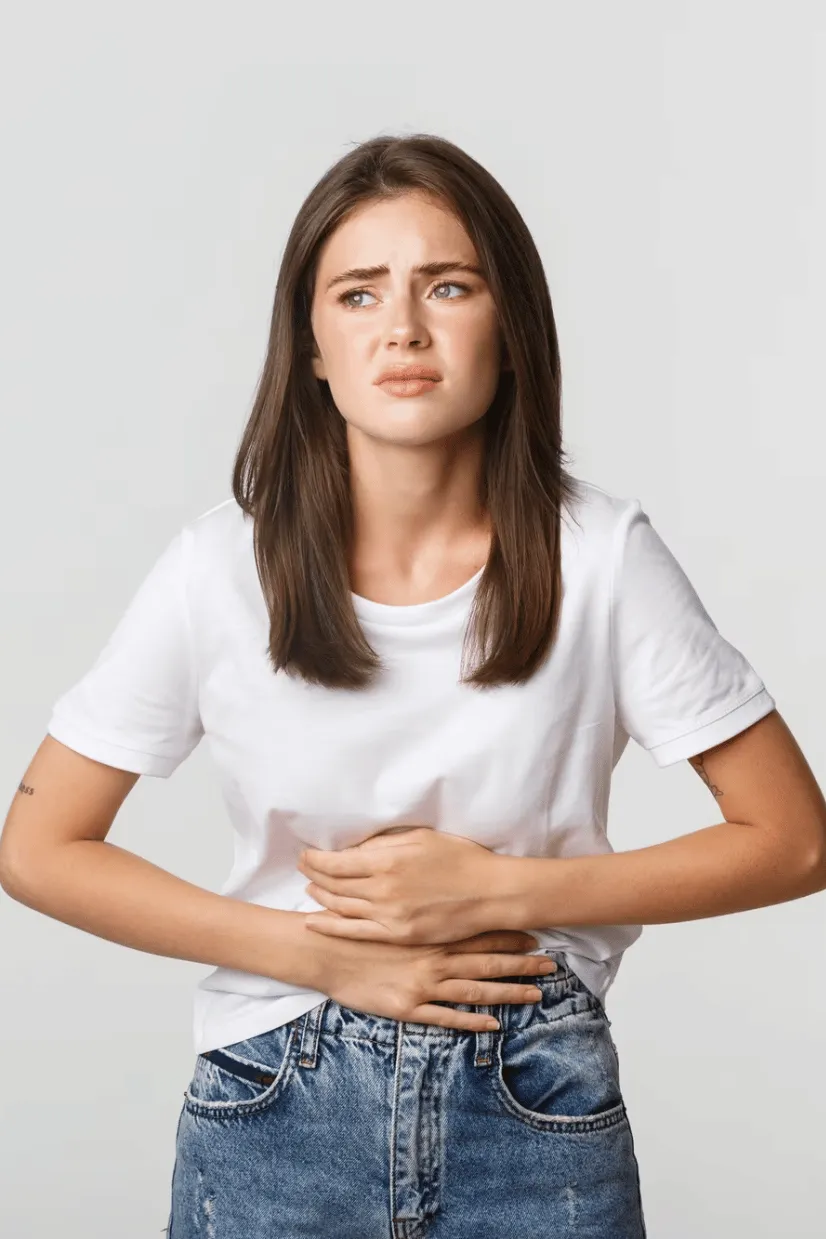 Woman holding stomach, representing digestion and gut health discomfort
