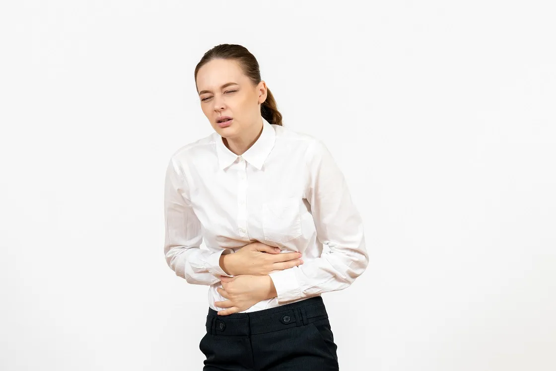 Woman clutching abdomen with discomfort, illustrating irritable bowel syndrome
