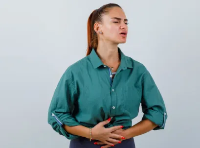 Woman holding abdomen in discomfort, illustrating irritable bowel syndrome symptoms