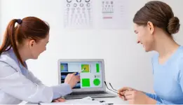 Doctor explaining test results on laptop to patient during medical consultation