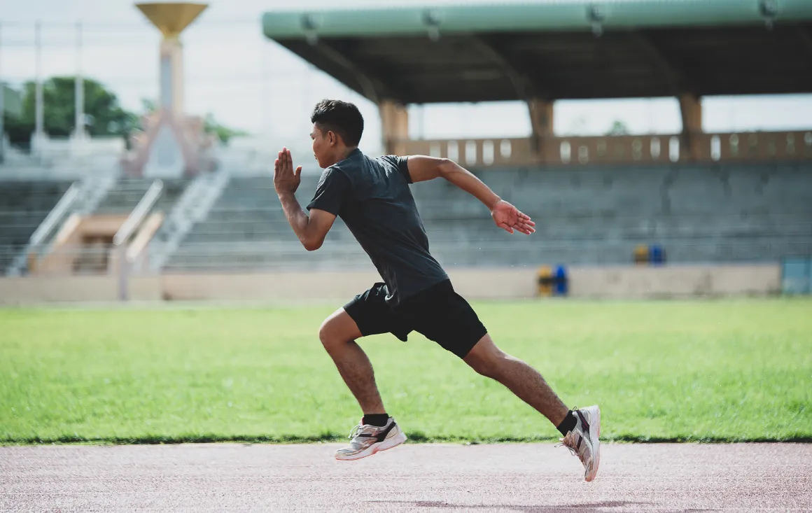 Male athlete sprinting on track, demonstrating speed, power, and athletic performance