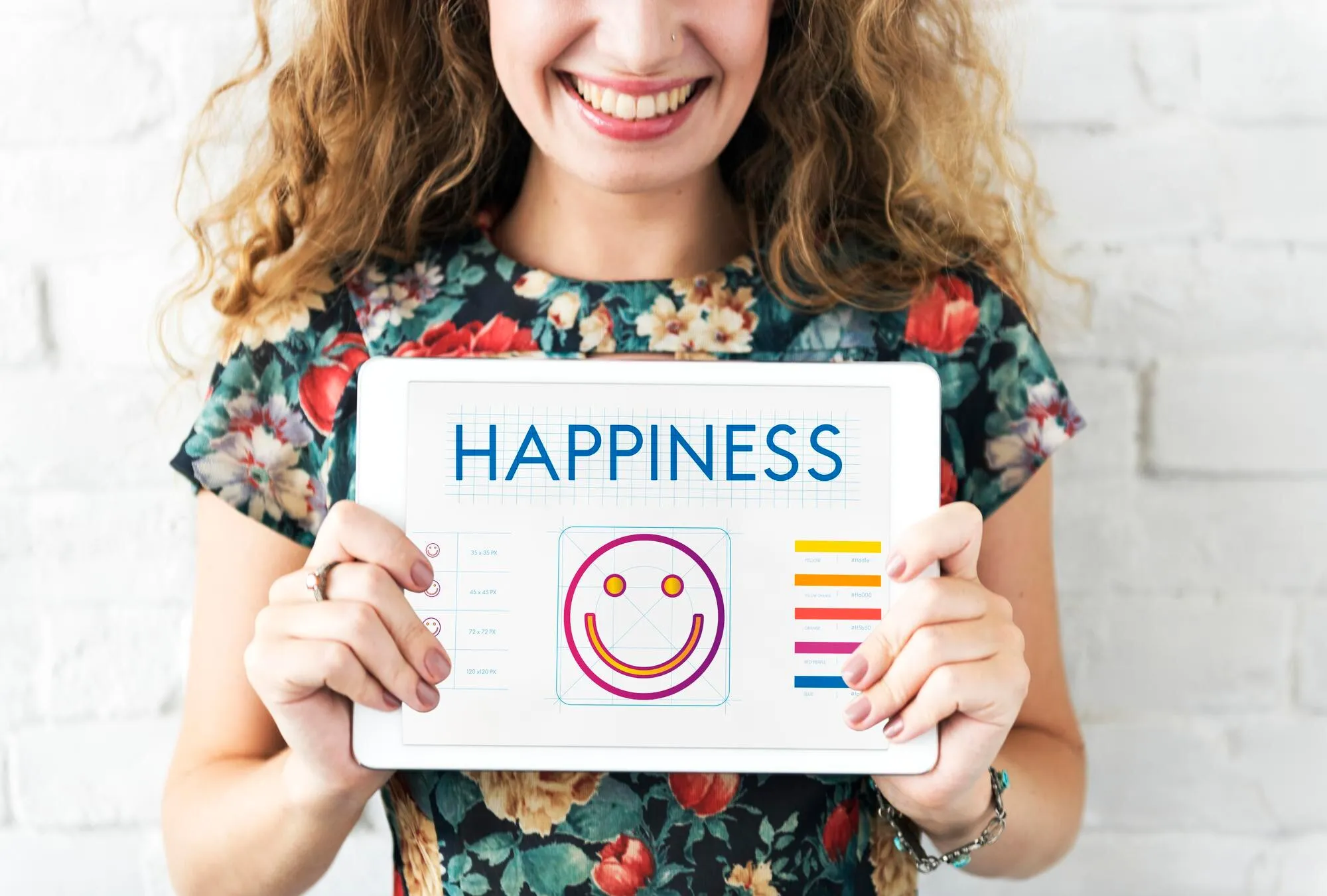 Smiling woman holding tablet displaying happiness and serotonin mood indicator
