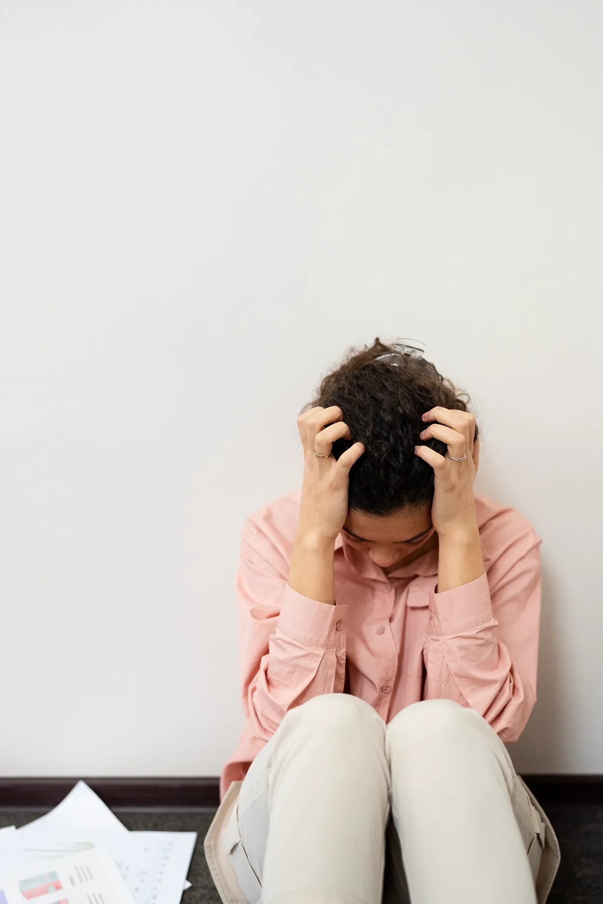 Person holding head with both hands, showing lack of drive and motivation