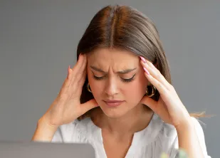 A woman holding her temples, showing stress and burnout syndrome